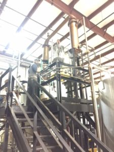 Aaron up on the catwalk above the 1500 liter copper pot still.